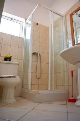 a bathroom with a shower and a toilet and a sink at Apartamento T3 encantador com piscina wifi e perto de praia in Santa Maria