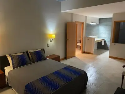 a bedroom with a large bed and a living room at Marimar in Praia