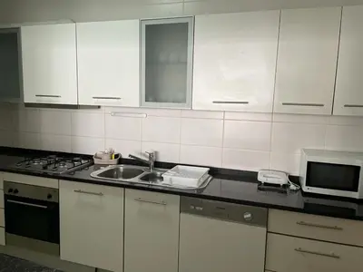 a kitchen with white cabinets and a sink and a microwave at Marimar in Praia