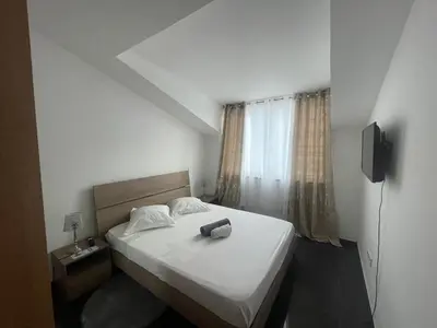 a bedroom with a white bed with a television on it at Chambre 3 Residencial Eunice in Praia