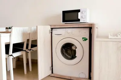 a washing machine with a microwave on top of it at Sunshine home Sal in Santa Maria