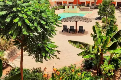 a pool with chairs and umbrellas in a resort at Sunshine home Sal in Santa Maria