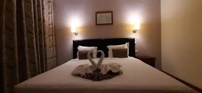 a bedroom with a bed with two swans on it at Atlantic Maio Hotel in Vila do Maio