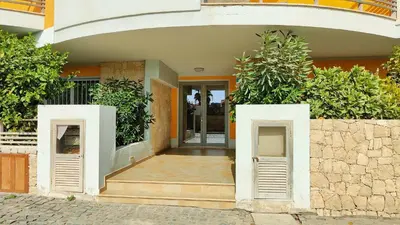 a house with two doors and a stone wall at Albis Harena - Meridiana Private Apartment Ocean View in Santa Maria