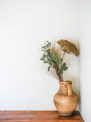 a vase with a plant in it sitting on a table at Madeira apartment in Mindelo São Vicente in Mindelo