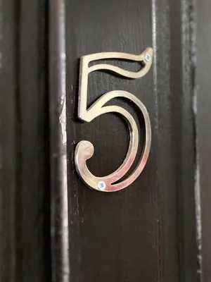 a wooden number five on a black post at Quarto Nº5 FANTASTIQUE- Central Praia in Praia