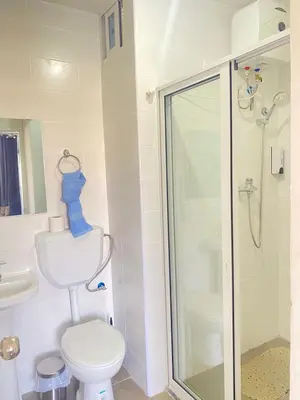 a bathroom with a toilet and a glass shower at Quarto Nº5 FANTASTIQUE- Central Praia in Praia