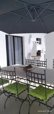 a table and chairs under an umbrella in a room at Praia Center in Praia