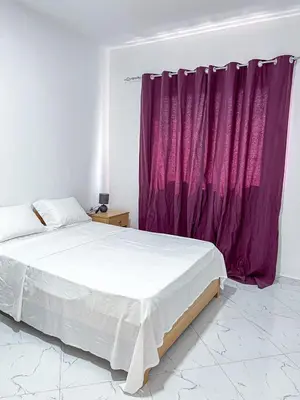 a bedroom with a bed and a purple curtain at Figo Apartamentos in Praia