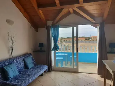 a living room with a couch and a large window at Holiday Properties Soleil Penthouse in Santa Maria