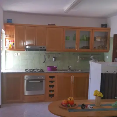a kitchen with wooden cabinets and a table with fruit at Villa Calhau in Mindelo