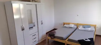 a small room with two beds and a cabinet at Villa Calhau in Mindelo