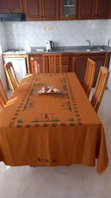 a table with an orange table cloth on it in a kitchen at SAM House in Mindelo