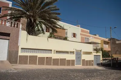 a white building with a palm tree behind it at Casa Matnik in Mindelo