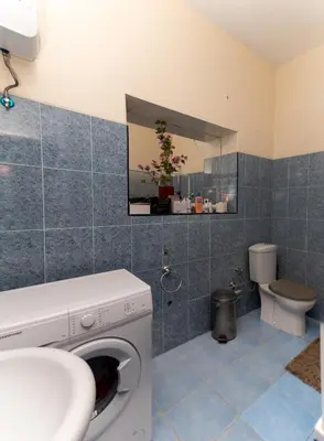 a bathroom with a washing machine and a toilet at Casa Matnik in Mindelo