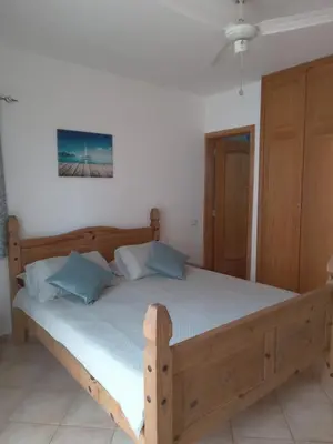 a bedroom with a wooden bed with blue pillows at Oasis Palmeira in Santa Maria