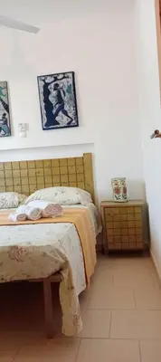 a bedroom with two beds and a wooden headboard at Farfalla in Vila do Maio