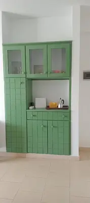 a kitchen with green cabinets in a room at Farfalla in Vila do Maio