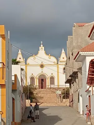 a group of people standing in front of a church at Farfalla in Vila do Maio