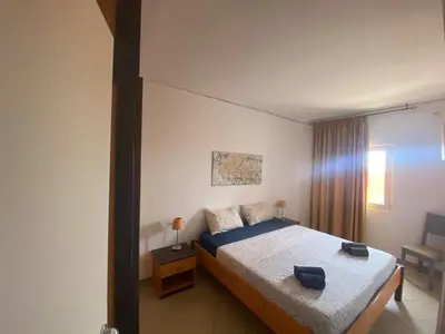 a bedroom with a large bed and a chair at MORADIAS I02/C in Prainha