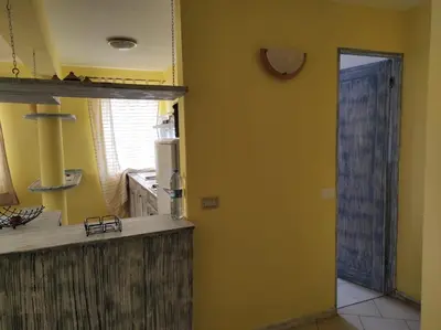 a kitchen with a yellow wall and a door to a kitchen at Holiday Properties Casa Laranja in Santa Maria