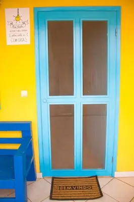 a blue door on a yellow wall with a mat in front at Relaxing Blue Flat near beach! in Calheta Do Maio