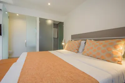 a bedroom with a large bed with orange pillows at Oasis Belorizonte in Santa Maria