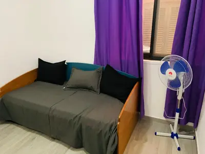 a bed with a fan in a room with purple curtains at Casa Mar e Sol - Murdeira - Ilha do Sal in Palha Verde