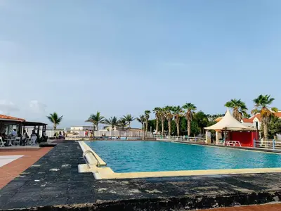 a swimming pool at a resort with palm trees at Casa Mar e Sol - Murdeira - Ilha do Sal in Palha Verde