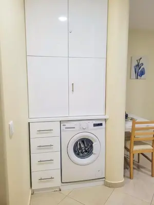 a washing machine in a kitchen with white cabinets at Castelinho Sal Lodge in Espargos