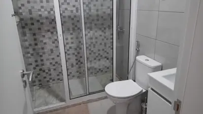 a bathroom with a shower and a toilet and a sink at Apartamentos Beira-Mar in Mindelo