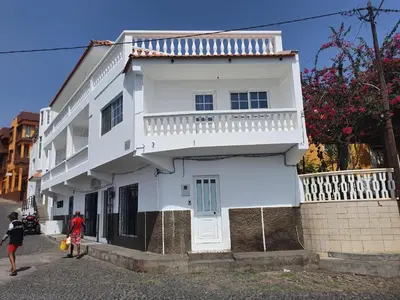 a white building with people walking in front of it at Seaview Apartment in Tarrafal