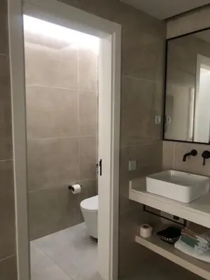 a bathroom with a sink and a toilet and a mirror at Apartamento Deluxe Santa Filomena in Mindelo