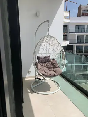 a swing chair sitting on a balcony on a building at Apartamento Deluxe Santa Filomena in Mindelo