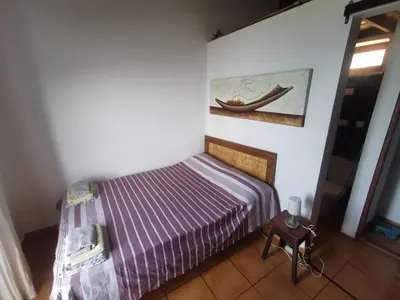 a bedroom with a bed and a painting on the wall at Casa Praia Tarrafal de Monte Trigo in Seladinha
