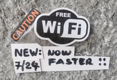 a group of stickers on the ground with the words free wifi at Casa Praia Tarrafal de Monte Trigo in Seladinha