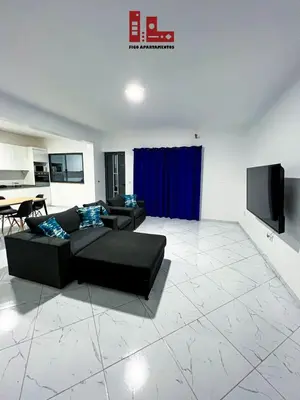 a living room with a black couch and a tv at Figo Apartamento Sol & Brisa Cidadela T2 in Praia