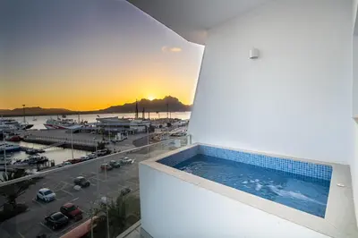 a swimming pool on a building with a view of a marina at Ouril Mindelo in Mindelo