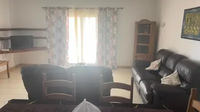 a living room with two leather couches and a window at Apartamento T2 equipado Vila Verde in Santa Maria