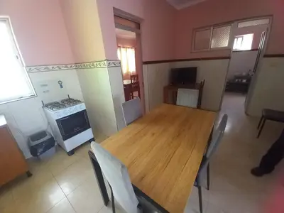 a kitchen with a wooden table and chairs and a stove at Casa Barreto in Tarrafal
