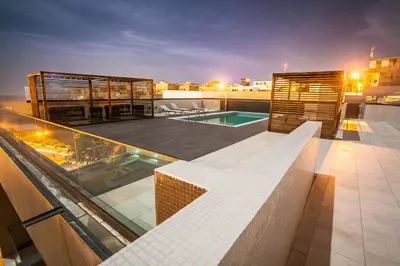 a building with a swimming pool on a roof at Hotel Pérola in Praia