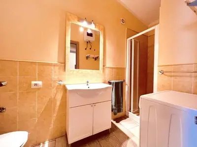 a bathroom with a white sink and a mirror at Cozy Apartment with Pool, near Beach and Center in Santa Maria