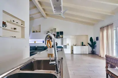 a kitchen with a sink and a living room at Beach Villa - By Bobbywashere in Santa Maria