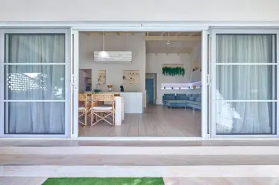 a living room and dining room with sliding glass doors at Beach Villa - By Bobbywashere in Santa Maria