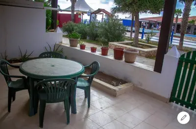 a green table and chairs sitting on a patio at Vila na Mágica Baía da Murdeira in Beirona