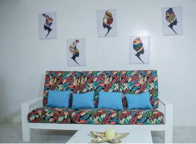 a couch in a room with pictures on the wall at Vila na Mágica Baía da Murdeira in Beirona