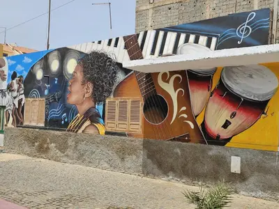 a mural of a woman with a guitar on a wall at Soleil Beach House in Santa Maria