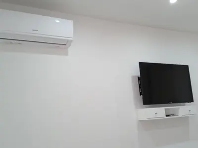 a flat screen tv attached to a white wall at chambre chez alcinda in Mindelo