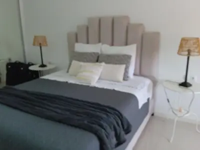 a bedroom with a large bed with two lamps at chambre chez alcinda in Mindelo