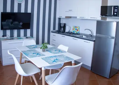 a kitchen with a table and chairs and a refrigerator at Porto Antigo 2 - Apt 54 in Santa Maria